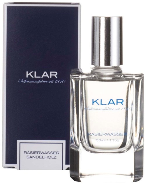 En parfymflaska med silverkork och en mörk låda märkt "KLAR" och "RASIERWASSER SANDELHOLZ."