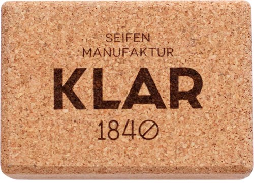 En tvålkaka med text på tyska, visar 'Klar 1840' och andra detaljer, på en beige bakgrund.