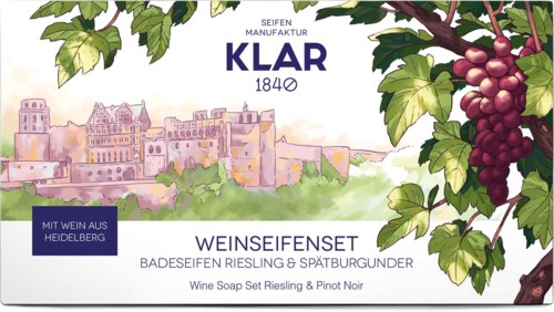 Etykieta z winogronami, widokiem na miasto i tekstem o zestawie mydeł wino, Riesling i Pinot Noir.