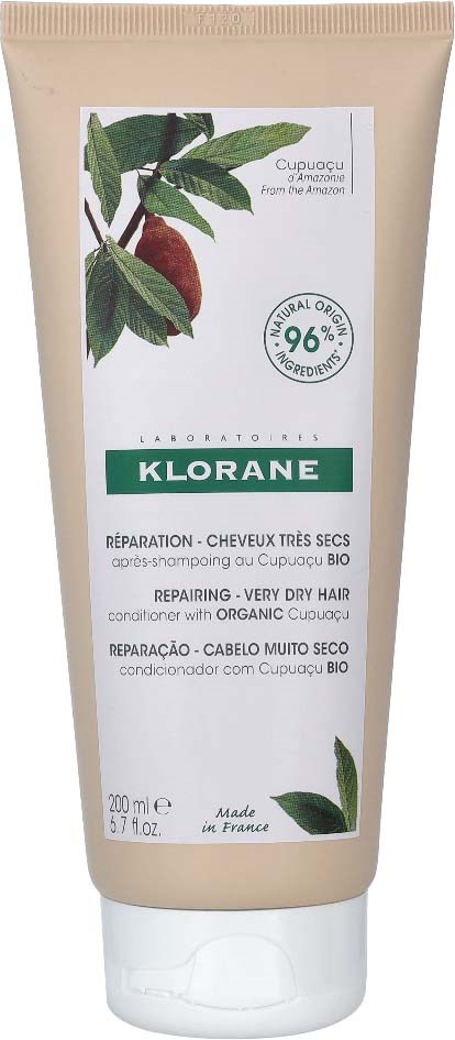 A beige tube of Klorane shampoo with green and white labels and an illustration of a plant with leaves and a fruit.