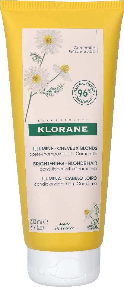 A yellow tube of Klorane shampoo for blonde hair with chamomile, 200 ml, made in France, with a chamomile plant illustration.