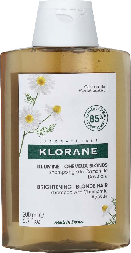 A transparent shampoo bottle with white and green label, featuring chamomile flowers, for blonde hair, 200ml, made in France.