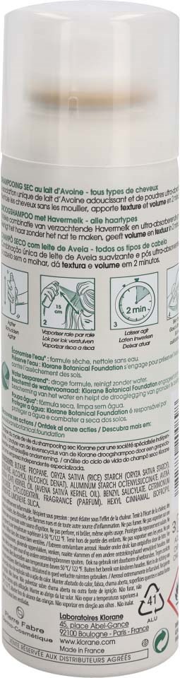 A white aerosol can with a beige cap, containing hair care product, featuring instructions and text in various languages.