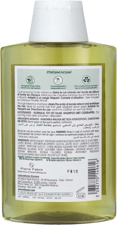 A transparent yellow-green shampoo bottle with a large white cap and a detailed label with instructions and ingredients.