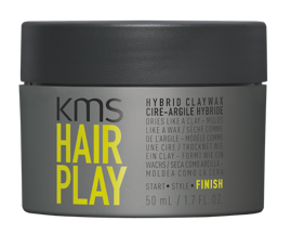 Ett grått burk med svart lock märkt "KMS Hair Play" för hårryckning, med gul och grå text.