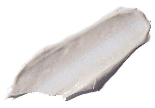 En stribe af hvid creme eller lotion på hvid baggrund, glat tekstur.