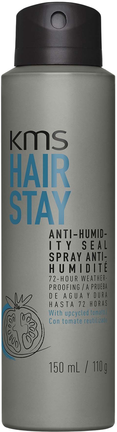 En grå flaske med sort låg, mærket KMS HAIR STAY anti-fugtighedsspray til hår.