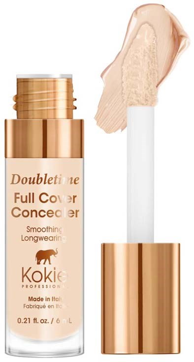 En beige flaska med foundation, ett vitt appliceringshölje och ett sminkprov.