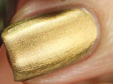 Närbild av en nagel målad med glänsande guldnagellack.