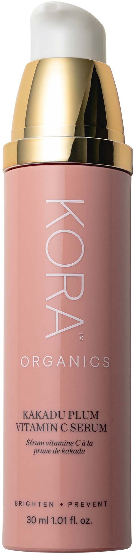 En rosa flaska med KORA Organics vitamin C-serum med en vit och guldlock.