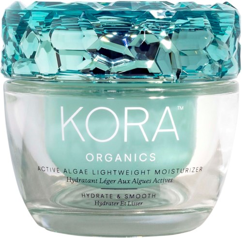 Słoik z niebieską, przypominającą kamień zakrętką, zawiera krem nawilżający KORA Organics, lekki, nawilżający i wygładzający.