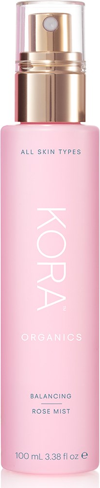 A pink spray bottle labeled KORA Organics Balancing Rose Mist for all skin types.