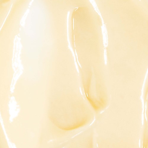 Close-up of smooth, creamy, yellowish surface, possibly food like cheese or lotion.