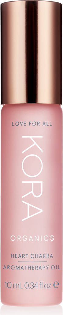 En rosa flaska med guldkork märkt 'KORA Organics Heart Chakra Aromatherapy Oil'.