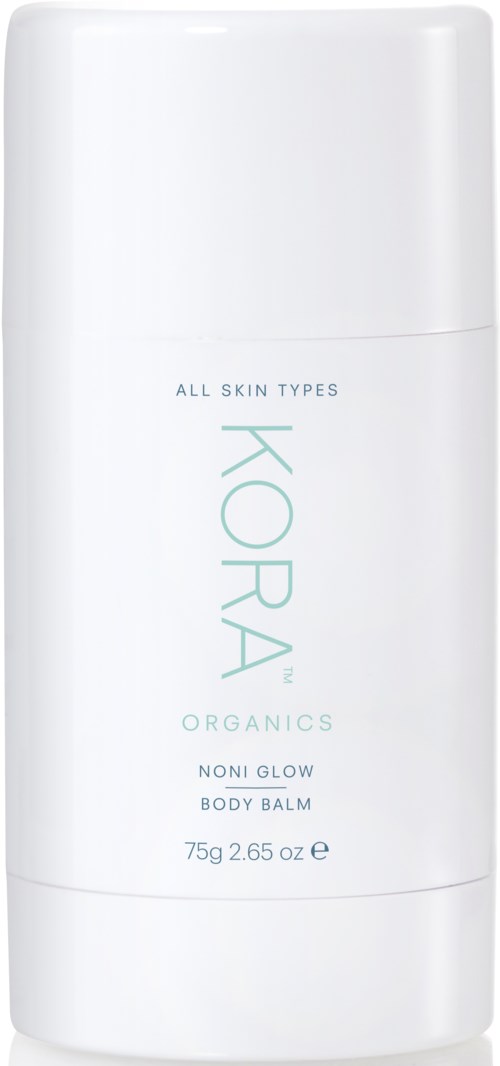 En vit flaska med ljus teal text, märkt "KORA ORGANICS NONI GLOW BODY BALM" för alla hudtyper.