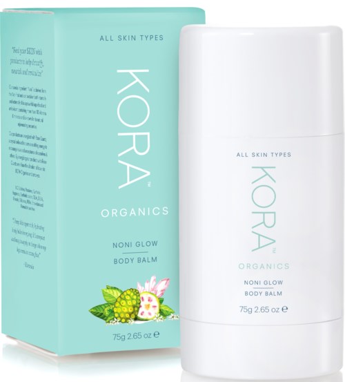 En vit flaska och mintgrönt förpackning för hudvård, märkt KORA Organics Noni Glow Body Balm, lämplig för alla hudtyper.