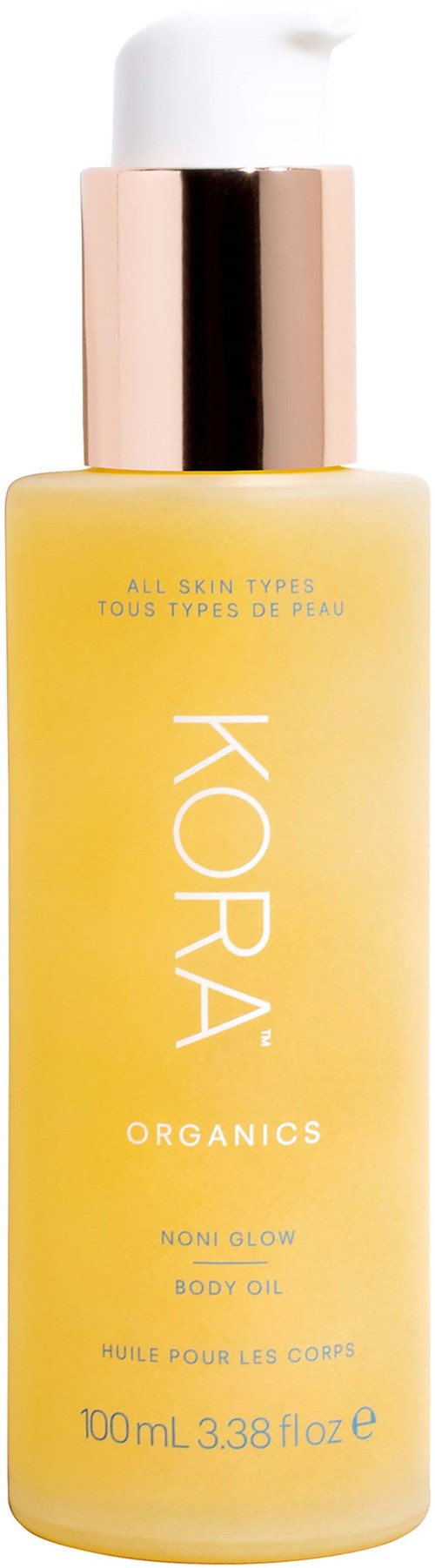 En gul flaska med KORA Organics kroppsolja med vit och guldpump; säger 'Noni Glow' och 'Alla hudtyper'.