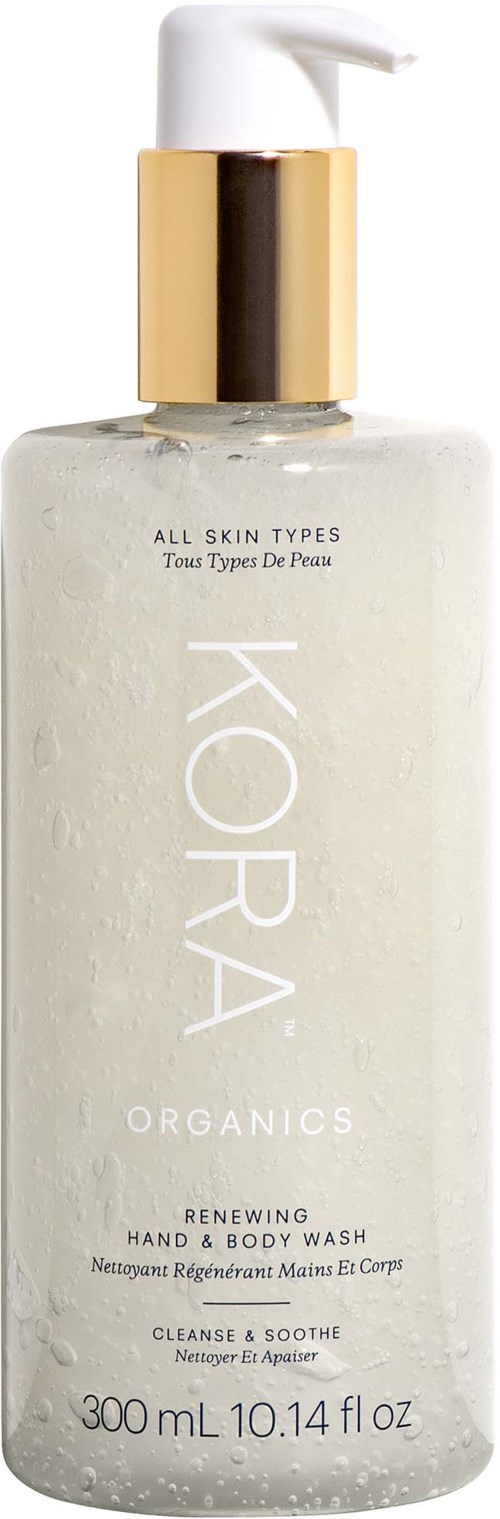 En tydlig flaska med vit pump, guldkrage och etikett som säger 'KORA Organics' för hand- och kroppstvål.