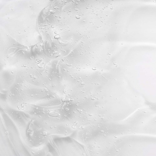 En nära bild av en vätskeytor med bubblor och släta texturer.