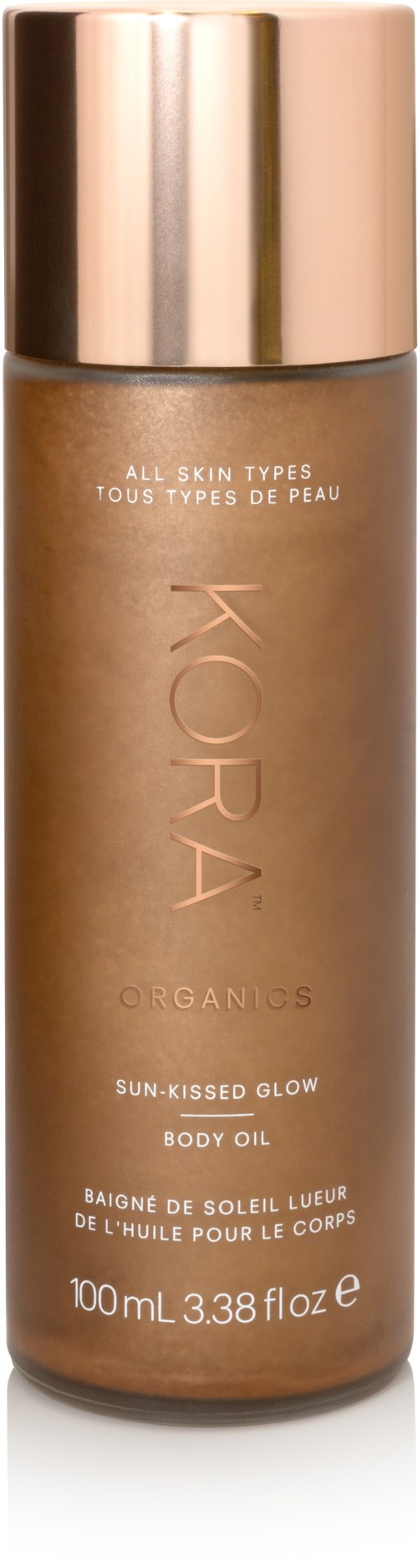 En brun flaske med guldhætte mærket KORA Organics Sun-Kissed Glow Body Oil til alle hudtyper.