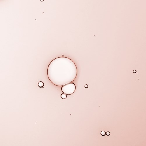 Two large bubbles and several smaller bubbles float against a light pink background.