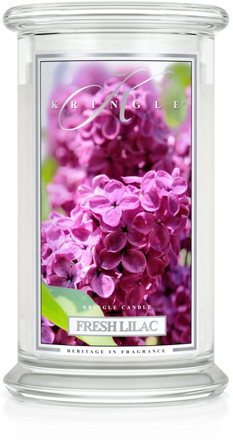 Ett ljus med en etikett som visar lila syrenblommor och orden 'Fresh Lilac' tillsammans med varumärket.