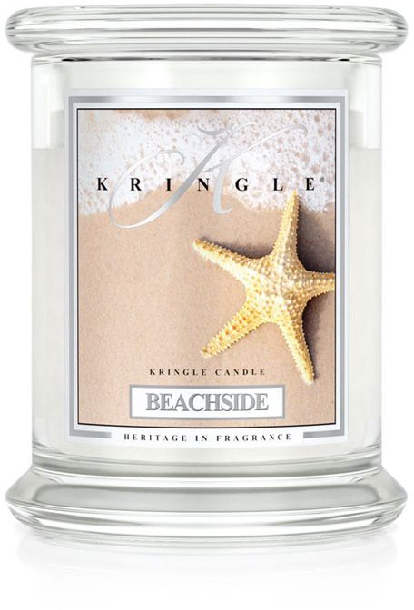 Ett ljus i ett glas med etiketten 'BEACHSIDE', havstjärna och sandbakgrund, från Kringles Heritage in Fragrance-serie.