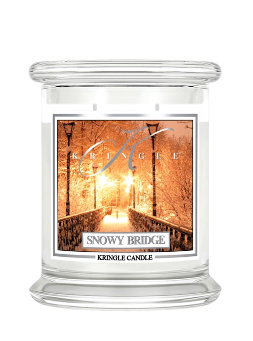 En klar ljuslykt märkta 'Snowy Bridge' med en vinterscen av träd och en bro vid solnedgången.