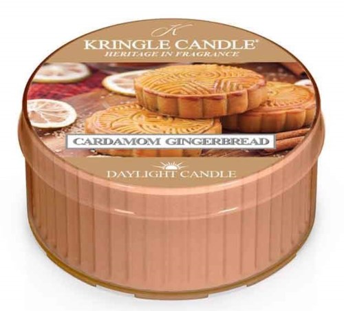 En rund ljusbehållare med en etikett som visar kardemumma-gingerbrödkakor och en doft som heter 'Daylight Candle.'