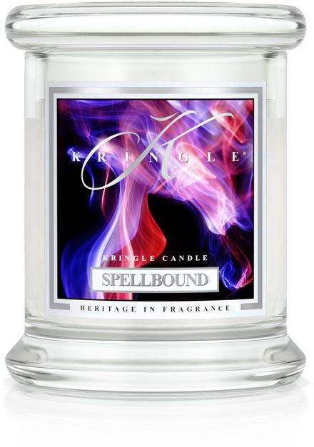 Ett klart glassljuslyktor med en etikett som visar lila och rosa rök och orden 'KINGLE CANDLE SPELLBOUND HERITAGE IN FRAGRANCE.'