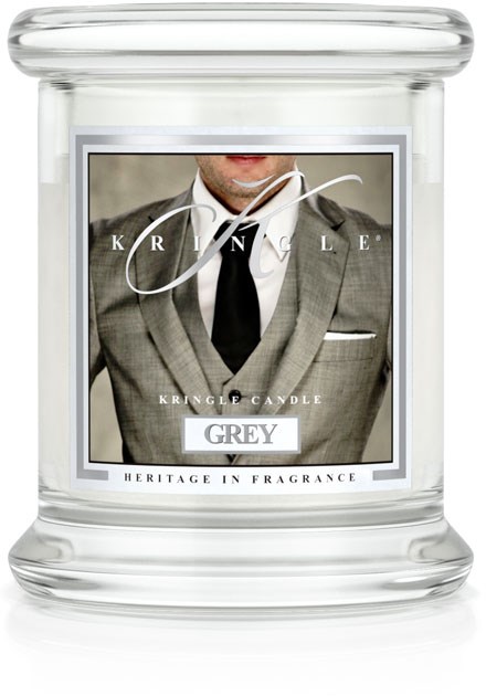 Ett tydligt glasljusglas med en etikett som visar en man i kostym, märkt 'Grey' för doft, och orden 'Heritage in Fragrance.'