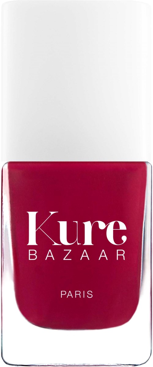 En neglelakkflaske med hvit hette, rød farge og Kure BAZAAR PARIS skrevet på den.