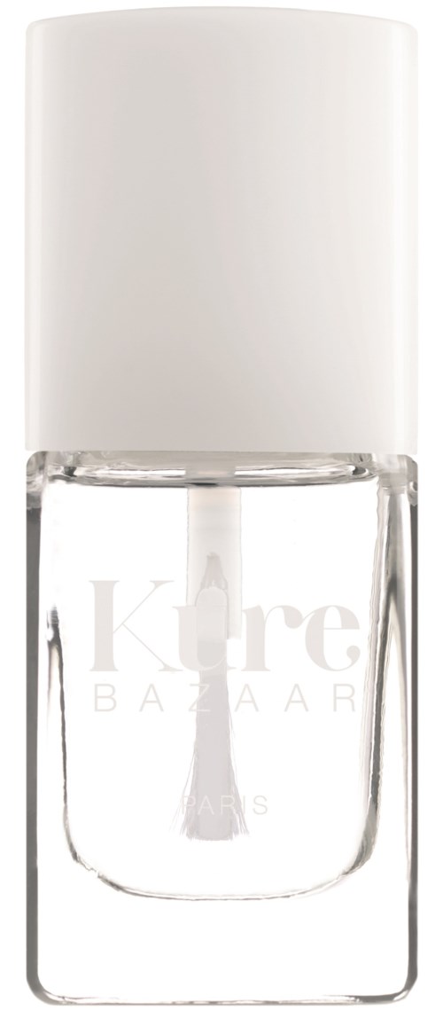 En klar glasflaske med neglelak med hvid top, mærket 'Kure BAZAAR' i lysegrå tekst.