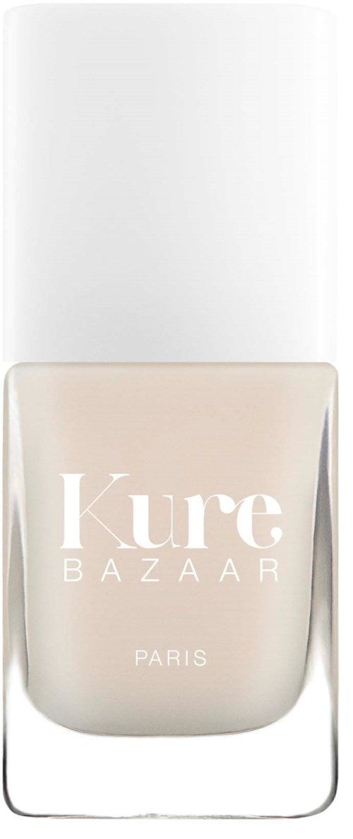 En klar glasflaske med hvid hætte, mærket 'Kure BAZAAR PARIS' i hvid tekst, med beige neglelak indeni.
