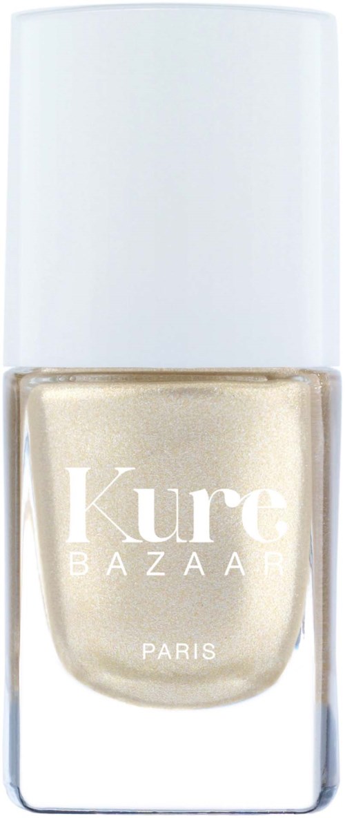 En flaska med guldskimrande nagellack, vit kork och klart glas. Etiketten säger "Kure Bazaar Paris."