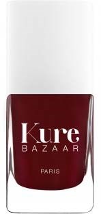 En flaske med mørkerødt neglelakk med merket "Kure Bazaar" på.