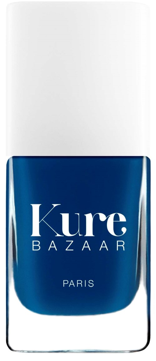 Blå nagellackflaska med vitt lock, märkt 'Kure BAZAAR PARIS' i vitt text.