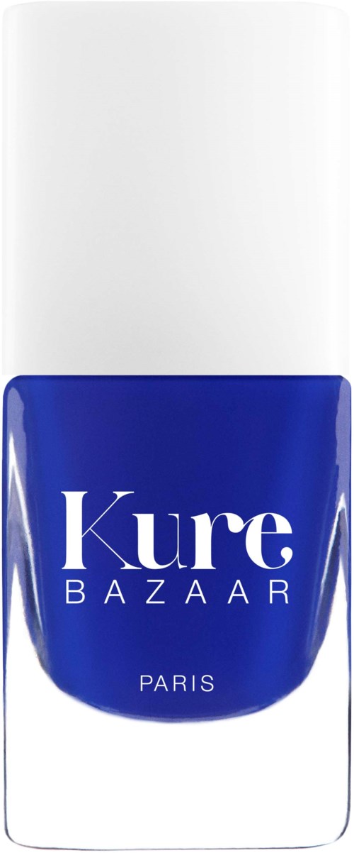 En blå neglelakkflaske med hvit lokk, med teksten 'Kure BAZAAR PARIS' på forsiden.