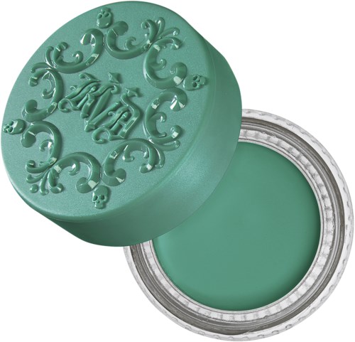 En rund, tealfärgad behållare med dekorativa svep på locket, som visar en matchande grön balm inuti.
