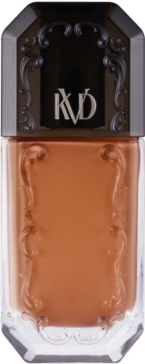 En foundationflaske med svart lokk og dekorative detaljer, med bokstavene 'KVD'.