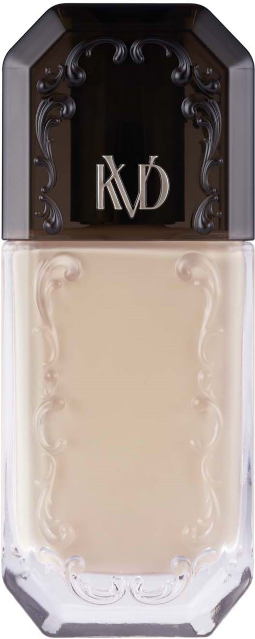 Ein Nagellackflasche mit schwarzem Deckel, goldenem Logo und beige Nagellack. Die Flasche ist rechteckig mit Dekorationen.
