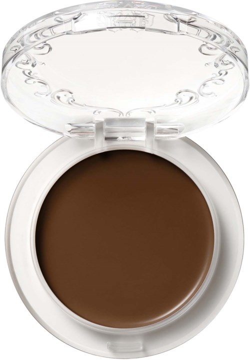 Rund brun makeup-Produkt i en hvit plastbeholder med gjennomsiktig lokk.