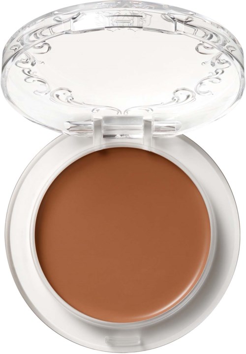 En liten dosa med brunt krämigt innehåll och lock som är genomskinligt. Det ser ut som en makeup- eller skönhetsprodukt.
