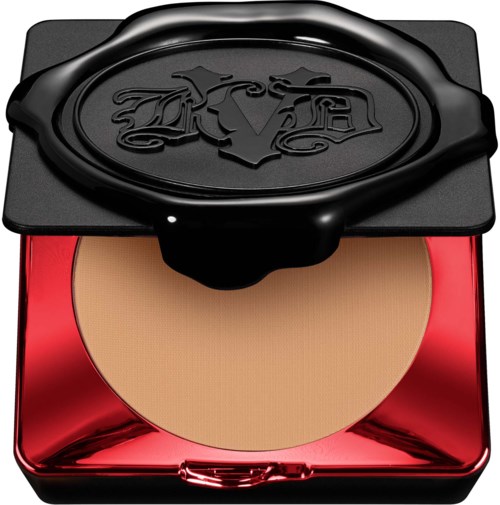 En kompakt makeup-puder med ett glänsande rött hölje och ett svart lock med ingraverat 'V'-märke.