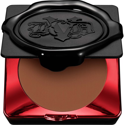 En kompakt makeuppuder med ett rött spegelreflekterande skal och ett svart lock med en logga.