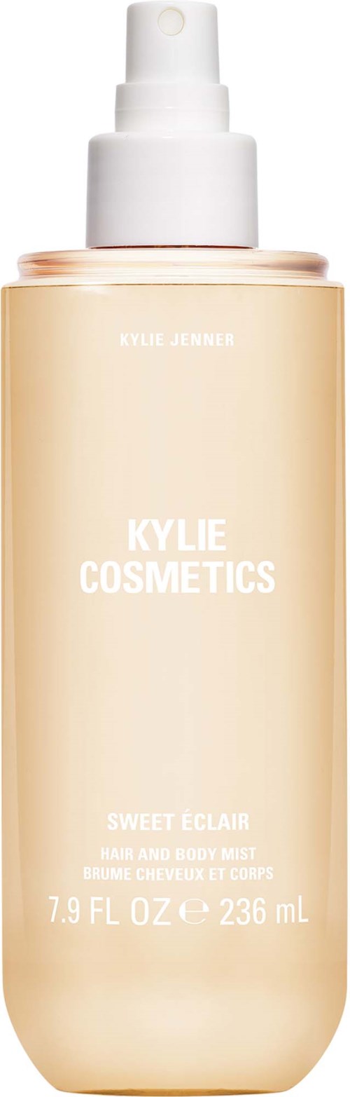 A beige spray bottle labeled 'Kylie Cosmetics' and 'Sweet Eclair', with a white spray nozzle on top.