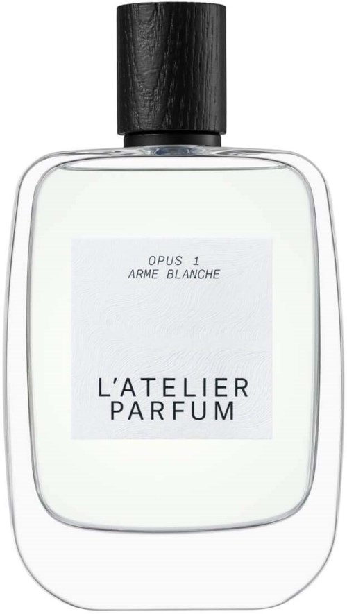 Ein Parfümflasche mit schwarzem Deckel, klarem Glas und weißem Etikett mit "Opus 1 Arme Blanche" und "L'atelier Parfum."