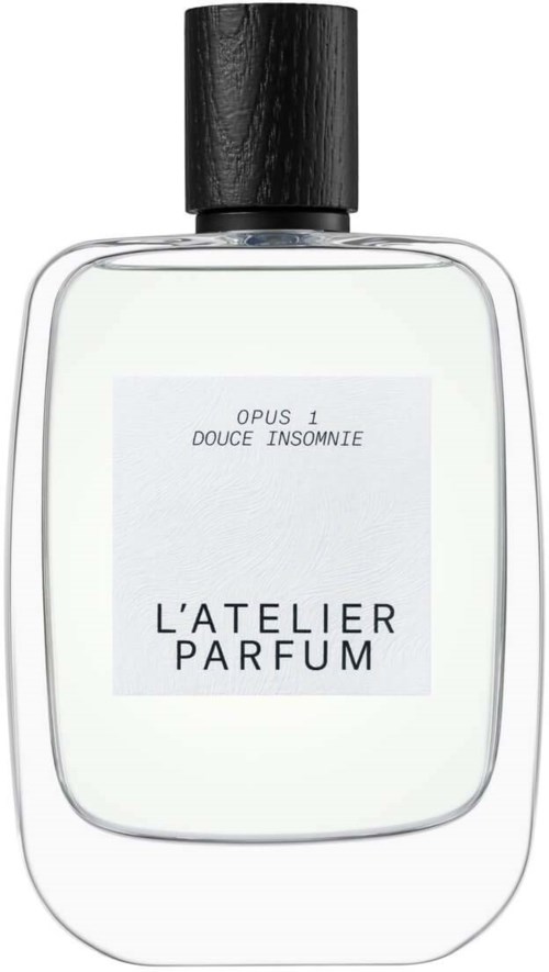 Butelka perfum z czarnym kapselkiem i białą etykietą. Na etykiecie jest napis "L'ATELIER PARFUM" i tekst.