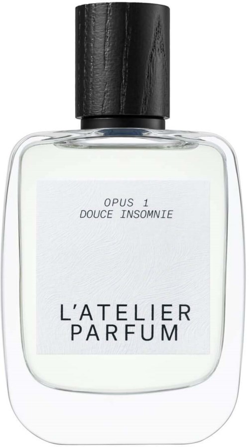 En parfymflaske med sort låg, klar foran med hvid etiket, teksten siger 'L'Atelier Parfum' og 'Opus 1 Douce Insomnie.'