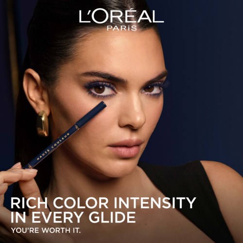 En närbild av en kvinna med mörkt hår och smink som håller i en makeup-stift, med text om L'Oréal-produkter.